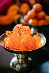 Top 10 Famous Street Foods in India You Must Try Close-up of Indian sweets Jalebi and Gulab Jamun in a brass bowl, ideal for cultural and food imagery.